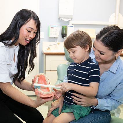 Dr Nina showing a child a dental model