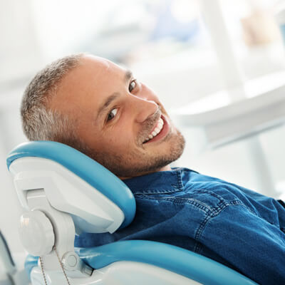 Happy man in the dental chair with a nice smile