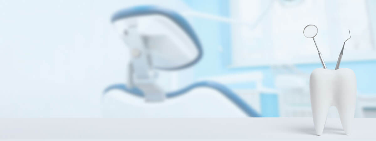Dental mirror and tools beside a model tooth