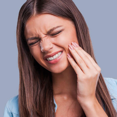 Woman grimacing with tooth pain
