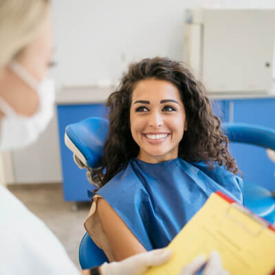 Smiling patient talking with her dentist at Princeton Dental