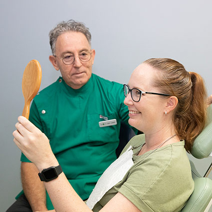 Smiling patient looking in a mirror